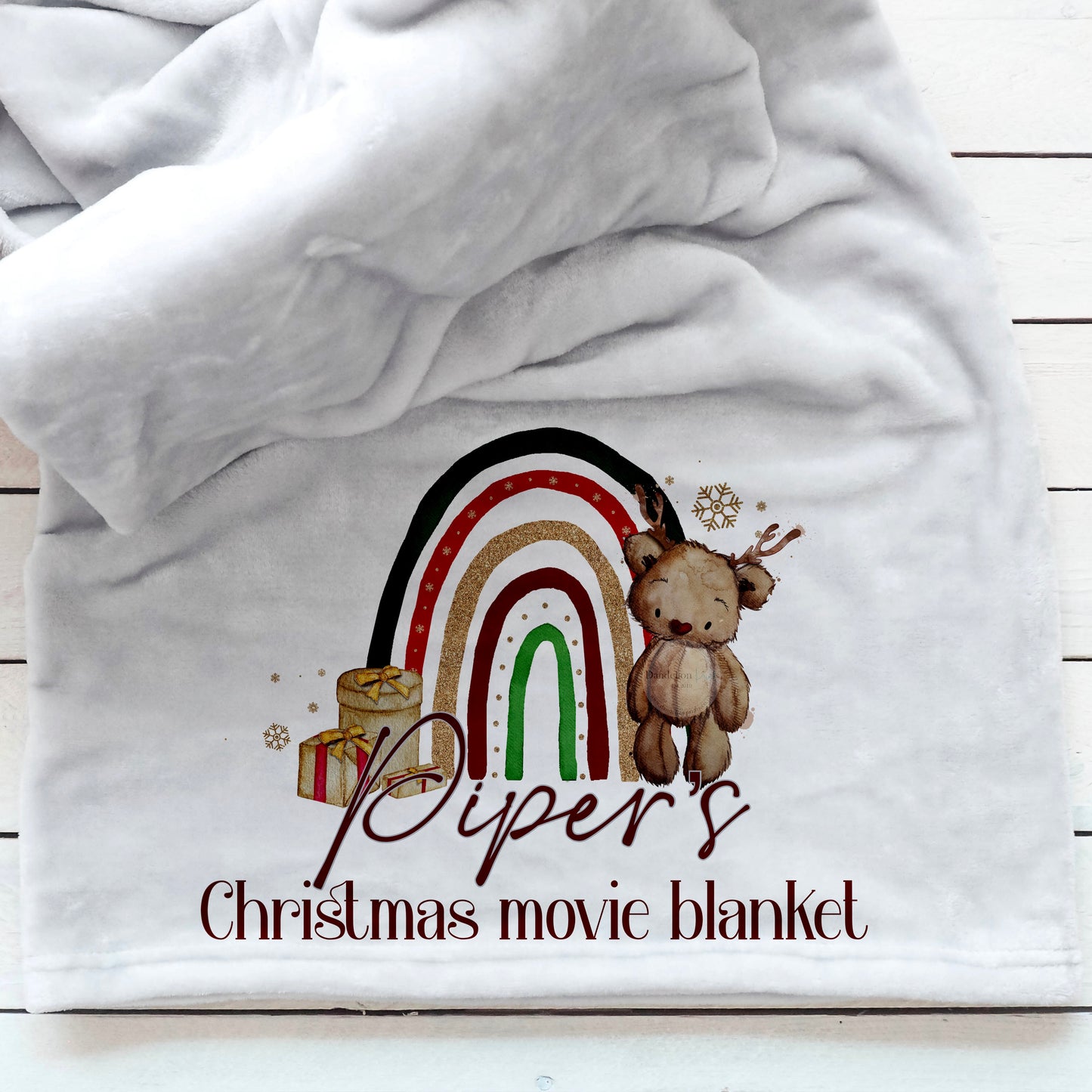 This is a luxury fleece blanket personalised for you for Christmas. Snuggle up on a winter evening with this gorgeous little festive bear printed blanket. There is a festive rainbow behind the bear. Personalised with NAME's Christmas movie blanket