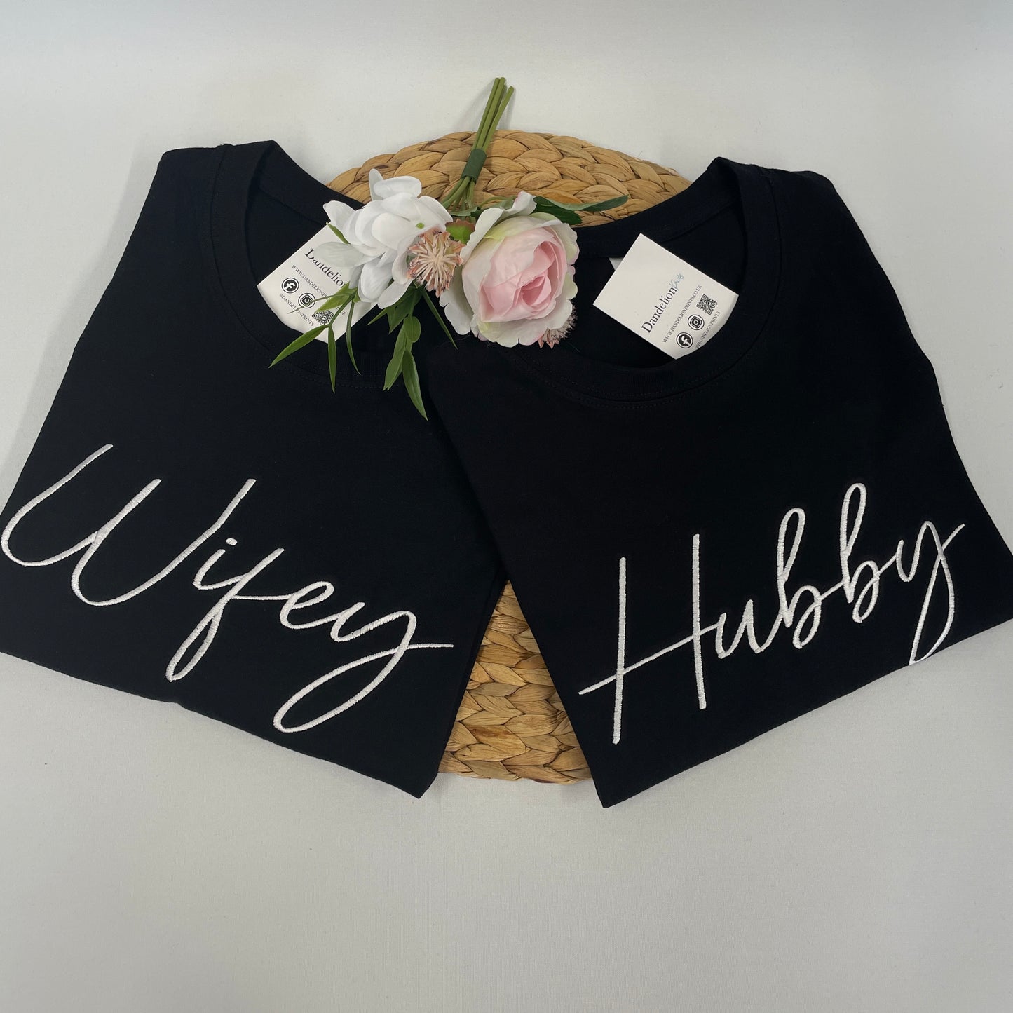 This is a pair of black t-shirts. Both t-shirts are embroidered with white thread on the chest. One reads Wifey and the other Hubby. This is a matching set ideal as a wedding gift for newly weds. Also available in white t-shirts.
