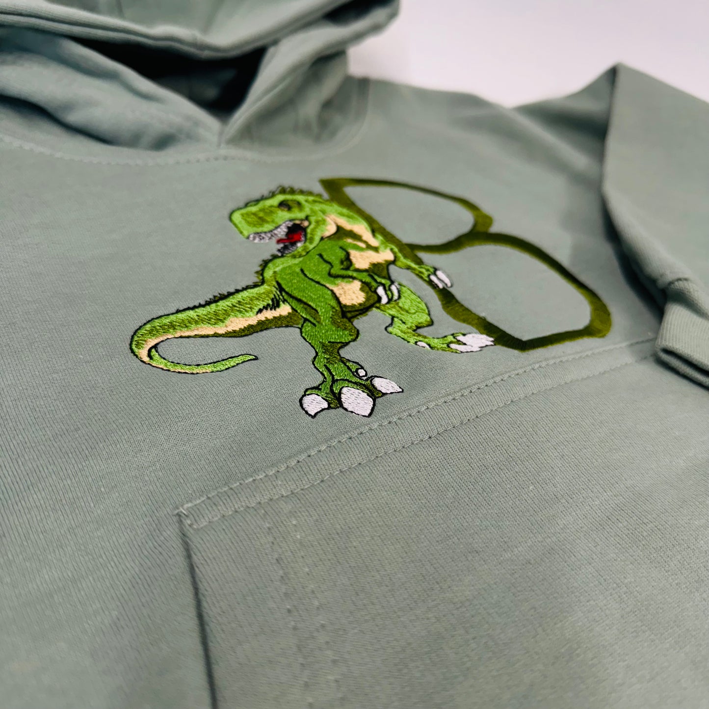 Adorable Sage Kids Hoodie with T-Rex Dinosaur and Embroidered Initial Detail