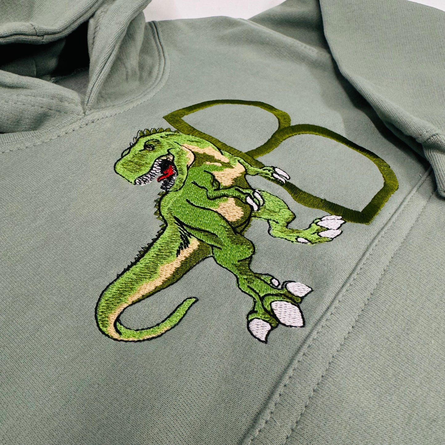 Adorable Sage Kids Hoodie with T-Rex Dinosaur and Embroidered Initial Detail
