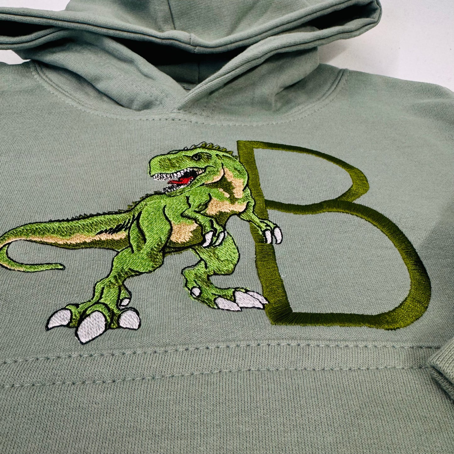 Adorable Sage Kids Hoodie with T-Rex Dinosaur and Embroidered Initial Detail