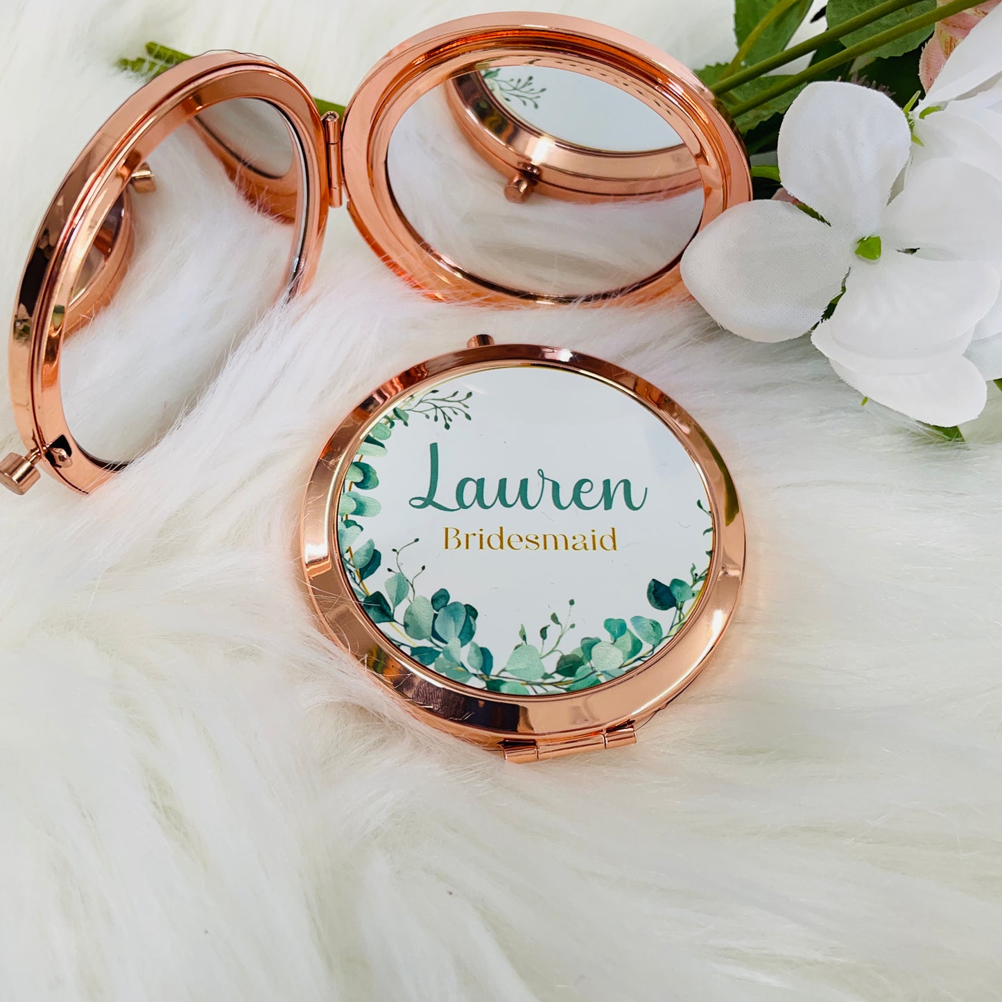 This is a rose gold metal compact mirror with button closure. Printed on the top is a frame of eucalyptus. In the middle is a name and a bridal party position. Great gift for her or as a bridal party gift idea.