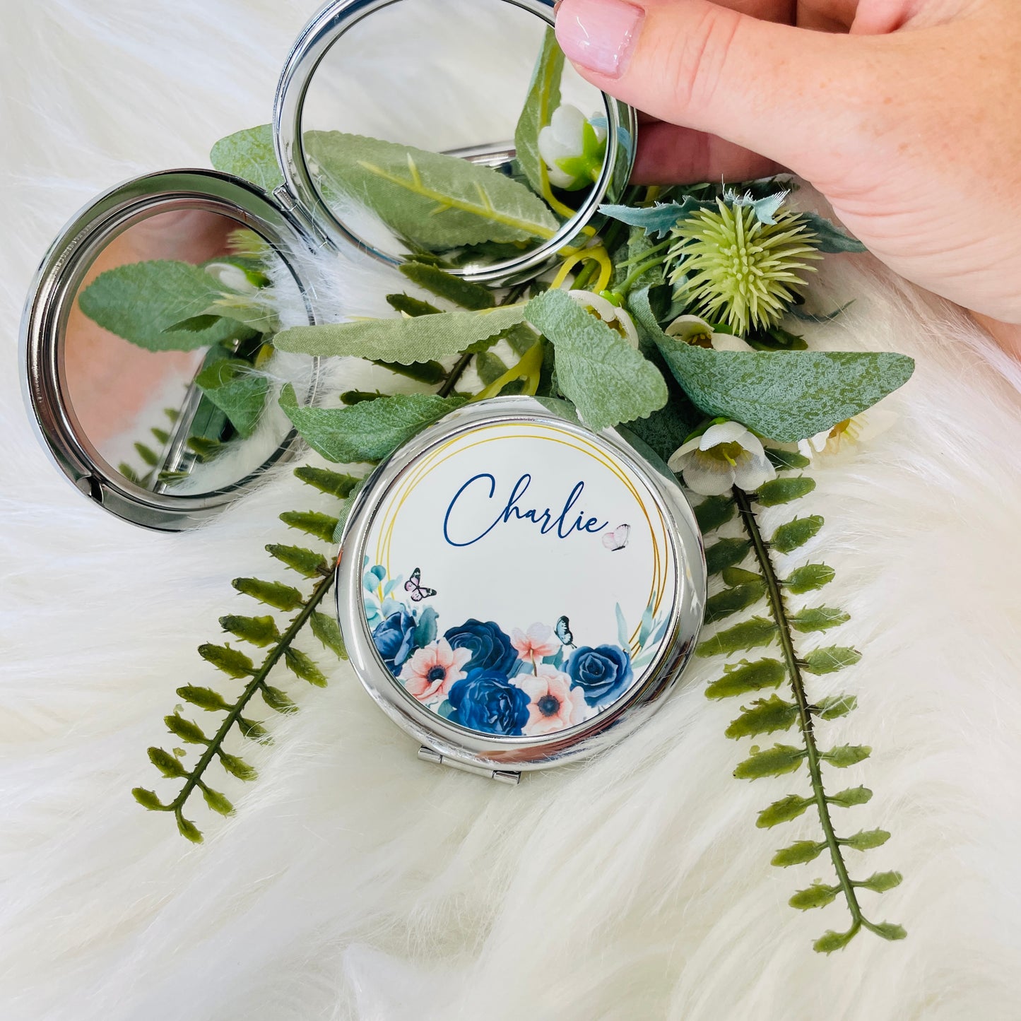 This is a double sided mirror in a silver case. One mirror is normal but the other is magnified. The lid of the mirror is printed with beautiful navy and blush roses with a butterfly and personalised with a name too