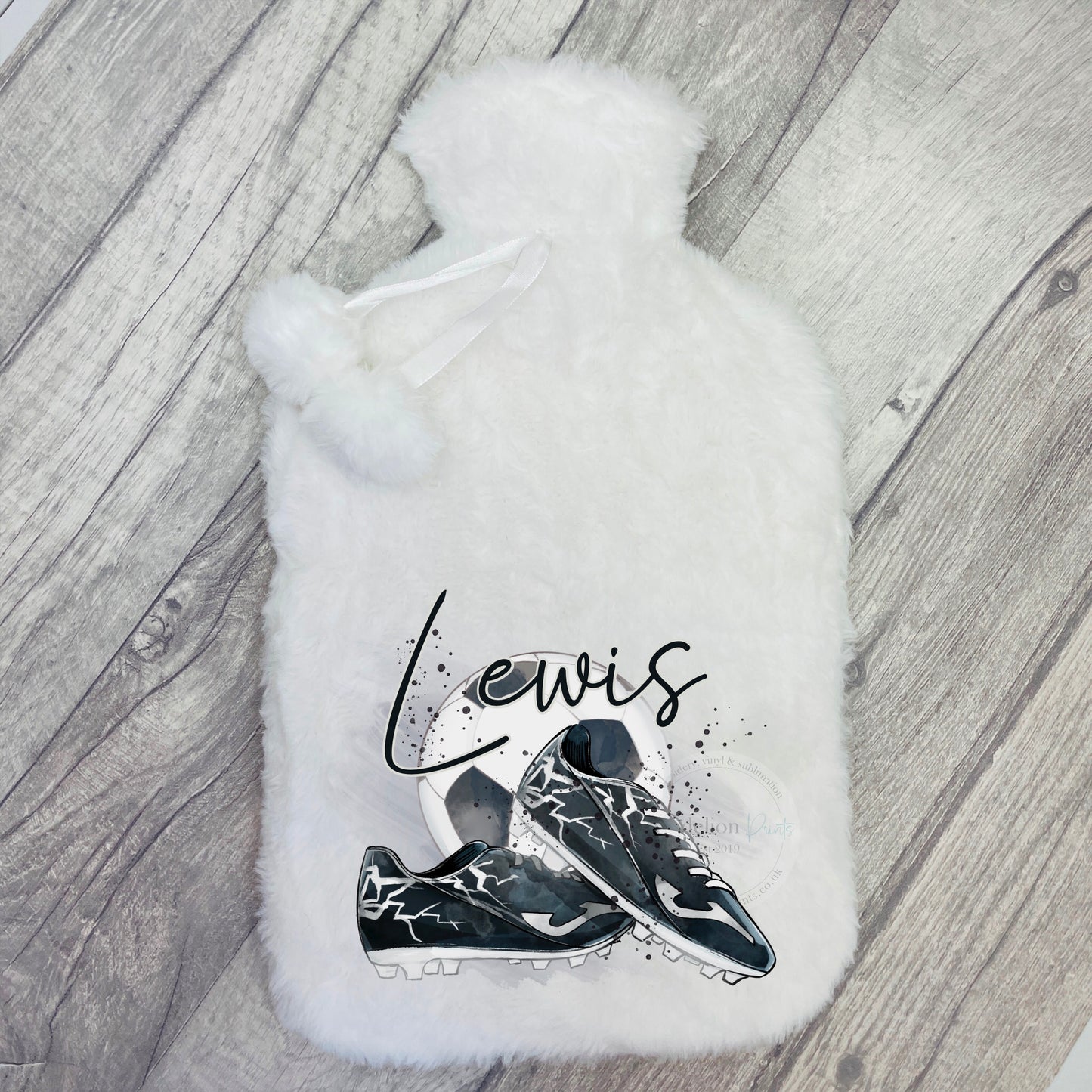 This is a hot water bottle printed with watercolour football boots and a football. A name is printed across the top of the image. The hot water bottle is super soft and fluffy. These come complete with the bottle and cover too.