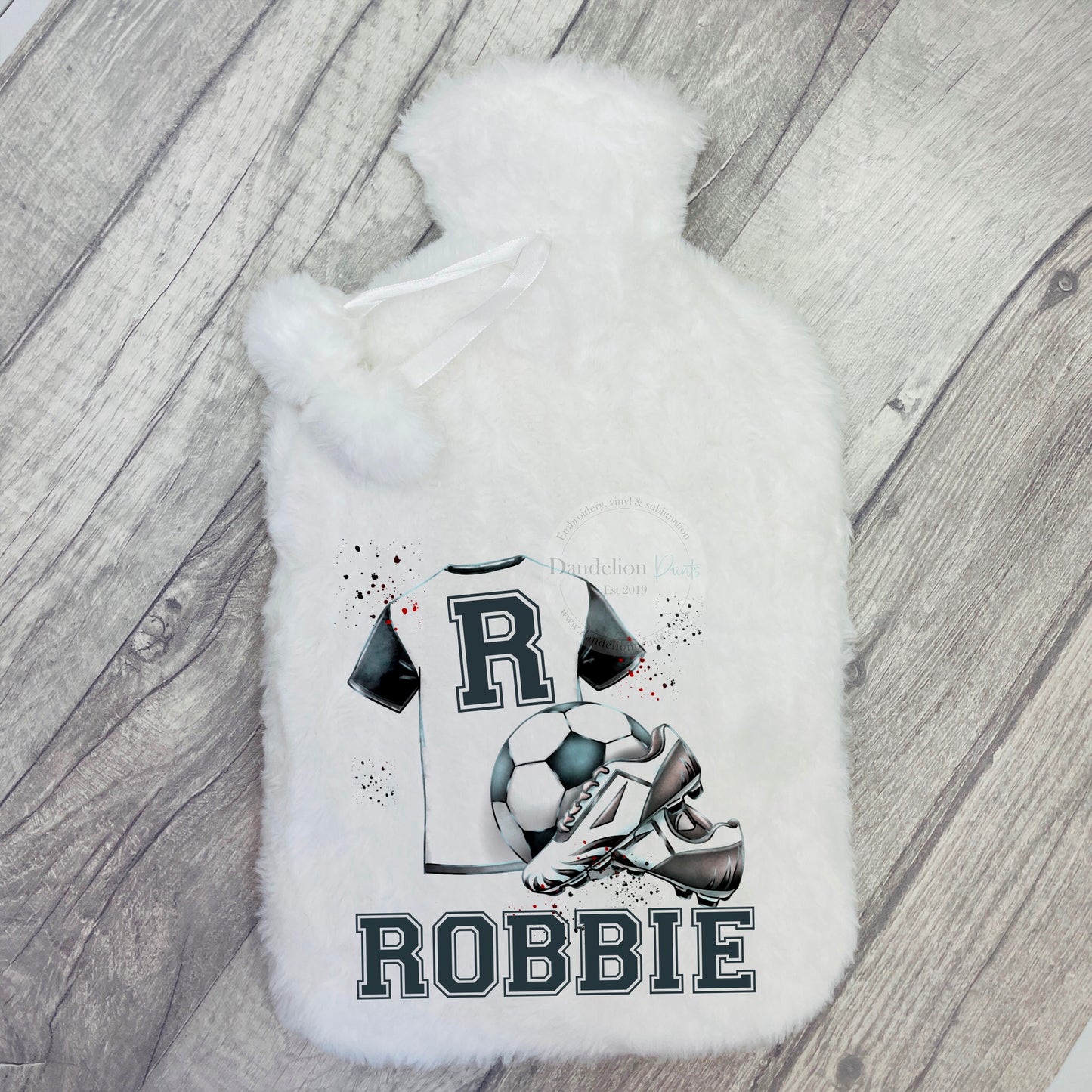 this is a white, super soft hot water bottle printed with a football shirt, ball and boots. A name is also printed along the bottom of the design. Any football fanatic will love this