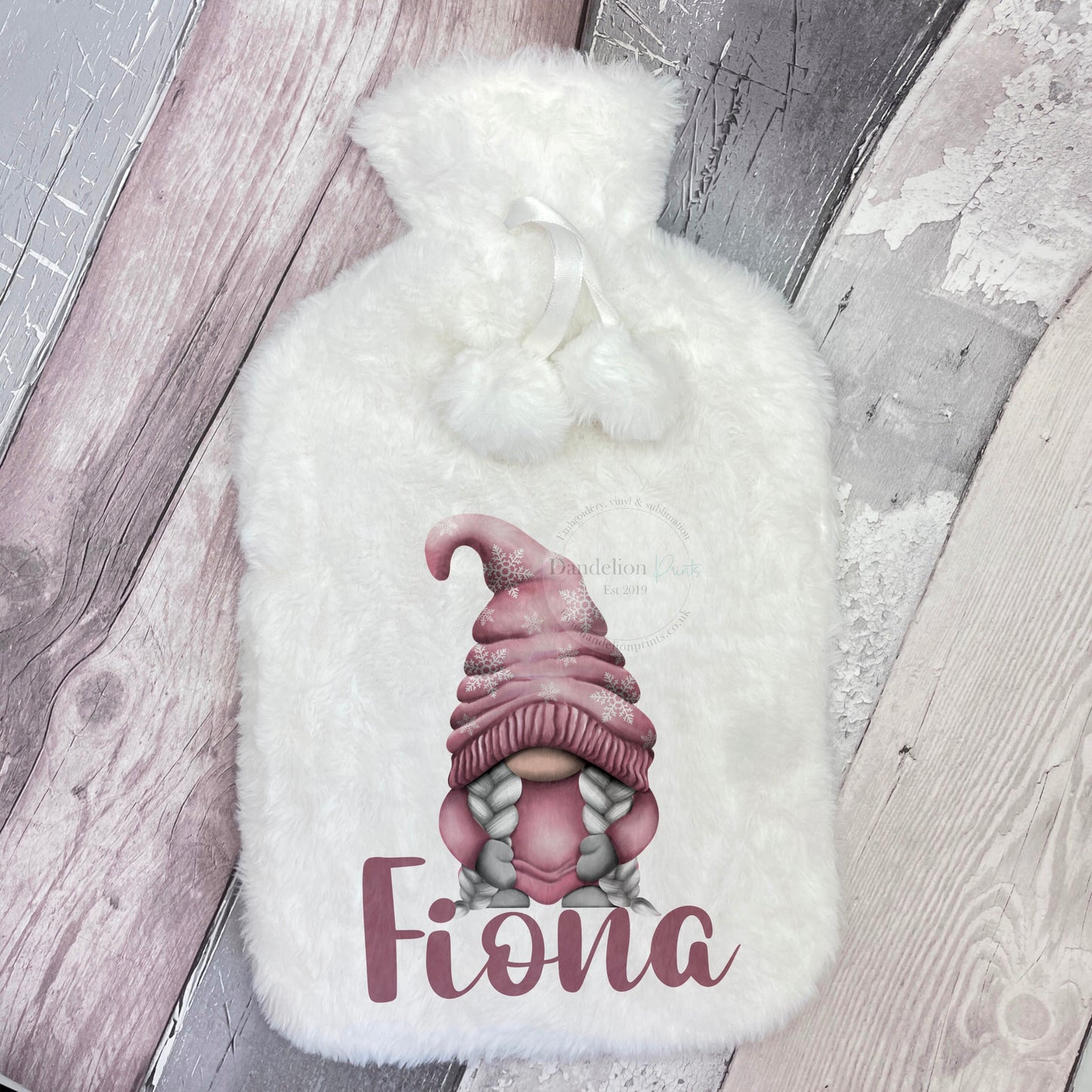 This is a white hot water bottle with hanging pom poms. The hot water is lovely and soft. Printed on the front is a cute pink gonk gnome with snowflakes on its hat. This is personalised with a name below the gonk image.