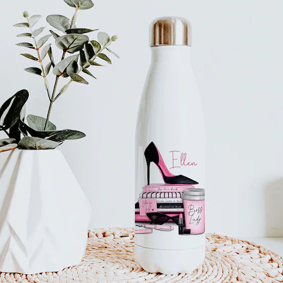 You can see a 500ml white flask with a silver lid. Printed on the flask is a boss lady design featuring a black and pink stiletto placed on top of black and pink books with female accessories too. Also personalised with a name.