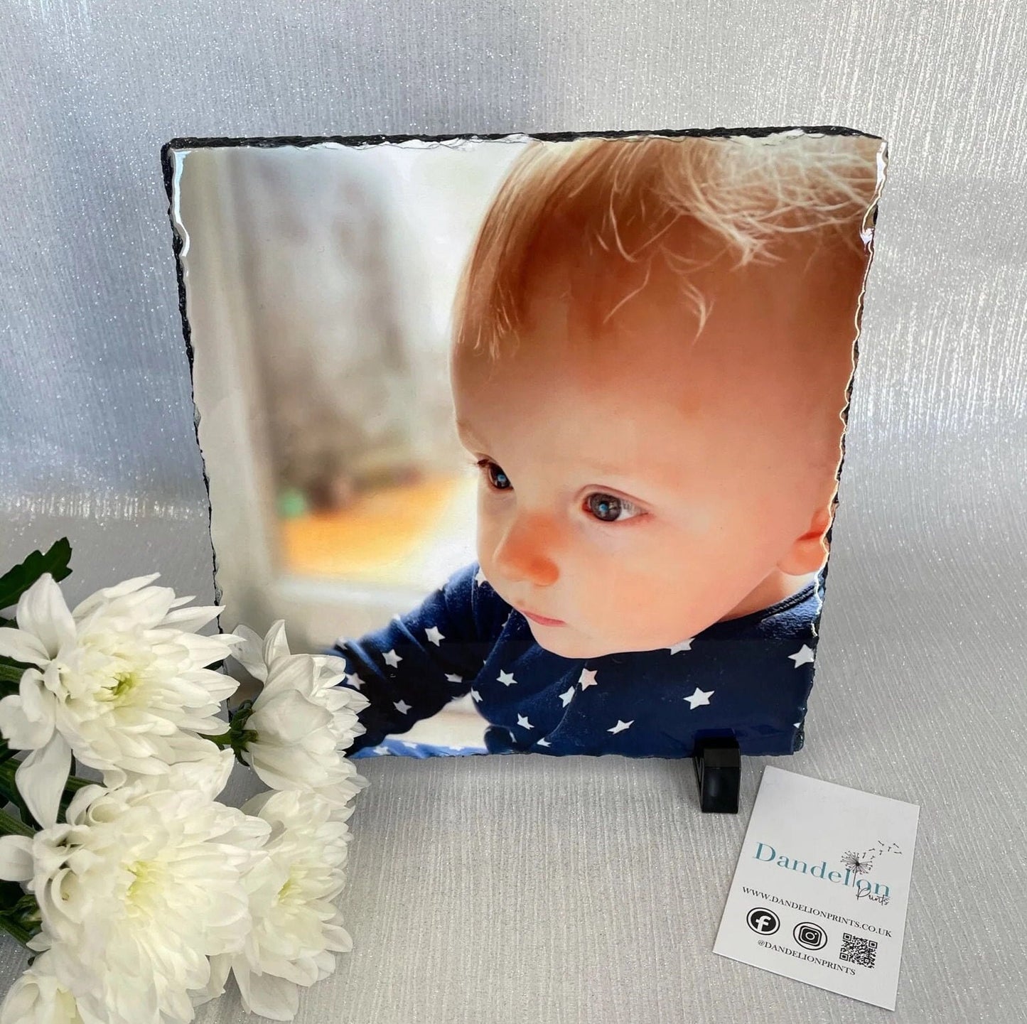 This is an image of a very glossy thick slate. This slate is printed on the front with a photo of your choice. The slate is resting on two feet which hold it upright.