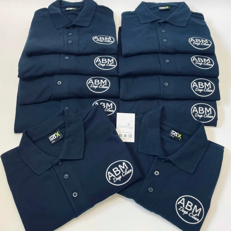 This is a stack of french navy polo shirts with three buttons. These shirts have all been embroidered with a company logo on the left breast by us.