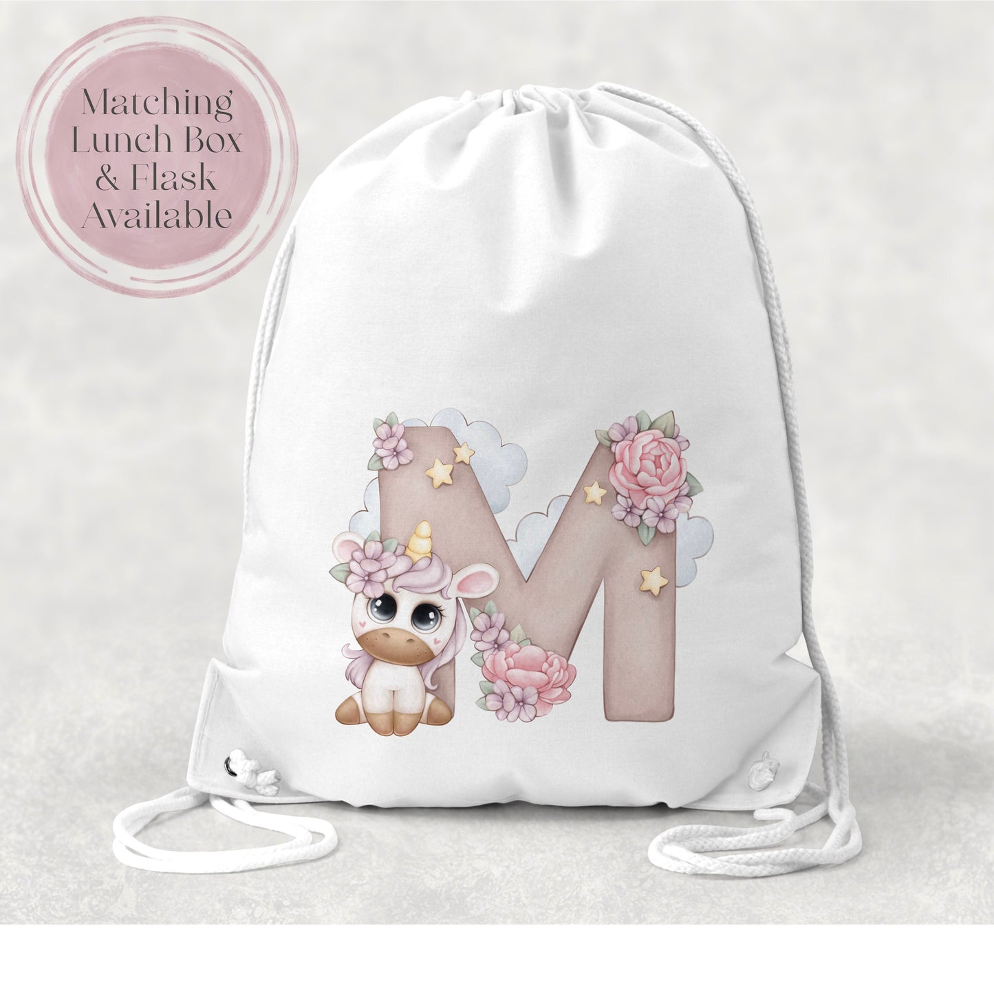 Image of a white PE bag with white drawstrings and a printed image to the front. The image is of an initial M with flowers and clouds and a cartoon unicorn with big eyes and flowers in its hair.