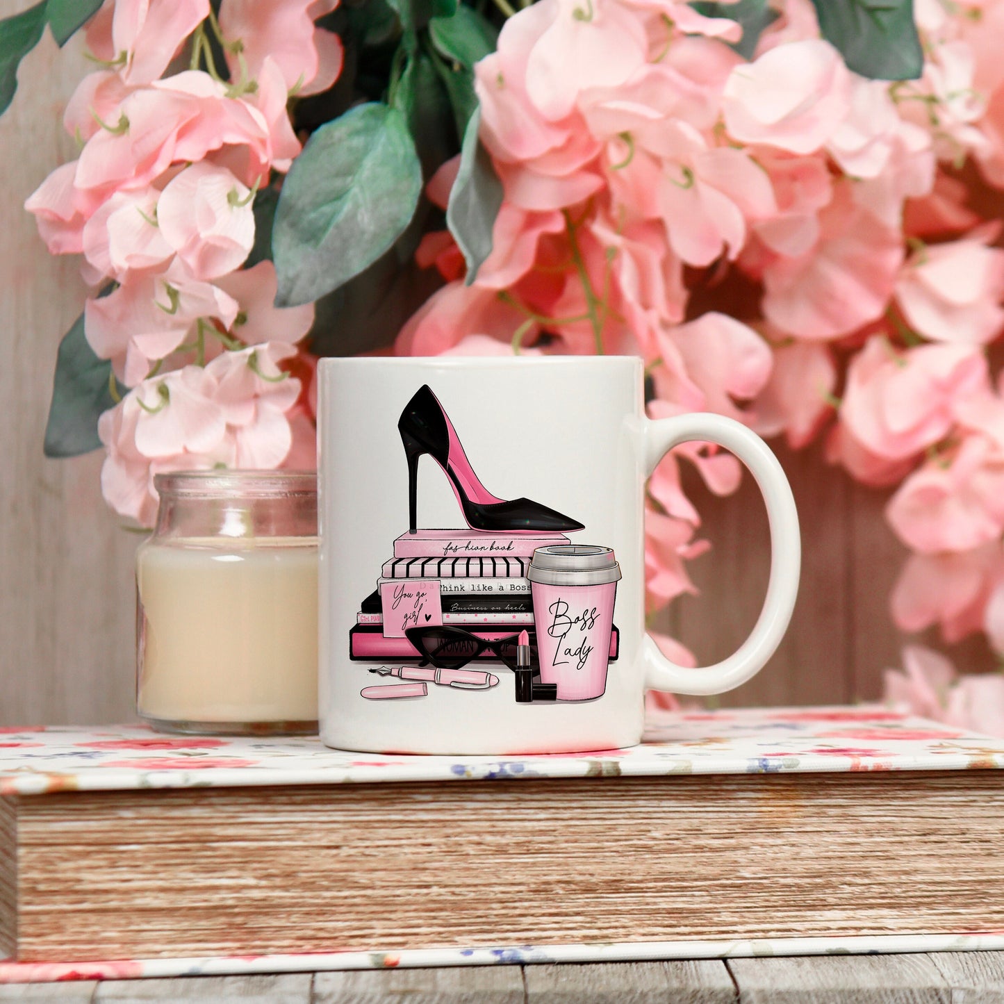 11oz white mug printed with a pink and black themed female boss design. The image features a stiletto, books, sunglasses, coffee mug, lipstick