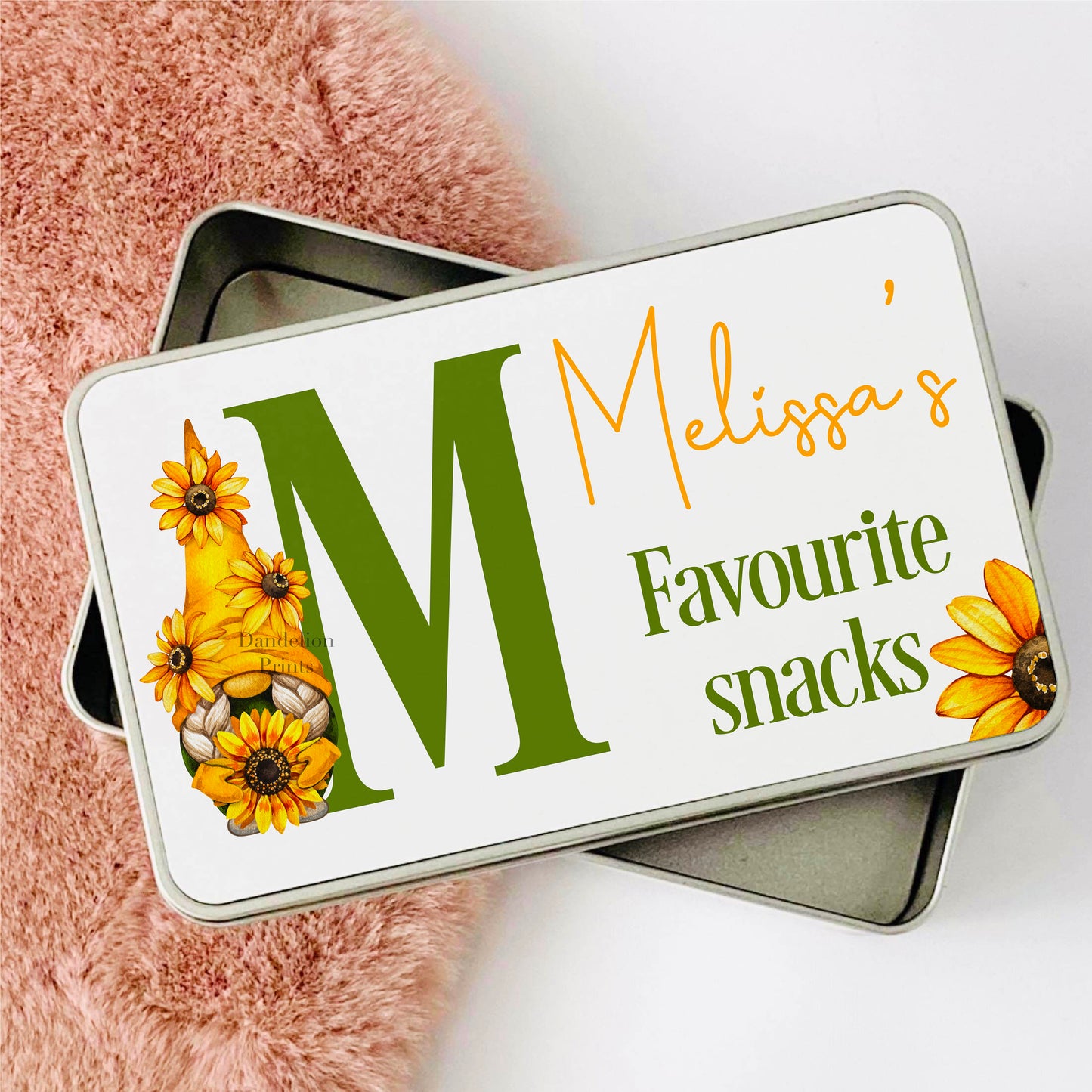 Metal Tin with A sunflower gnome standing next to a green alphabet letter. The tin is also personalised with a name.