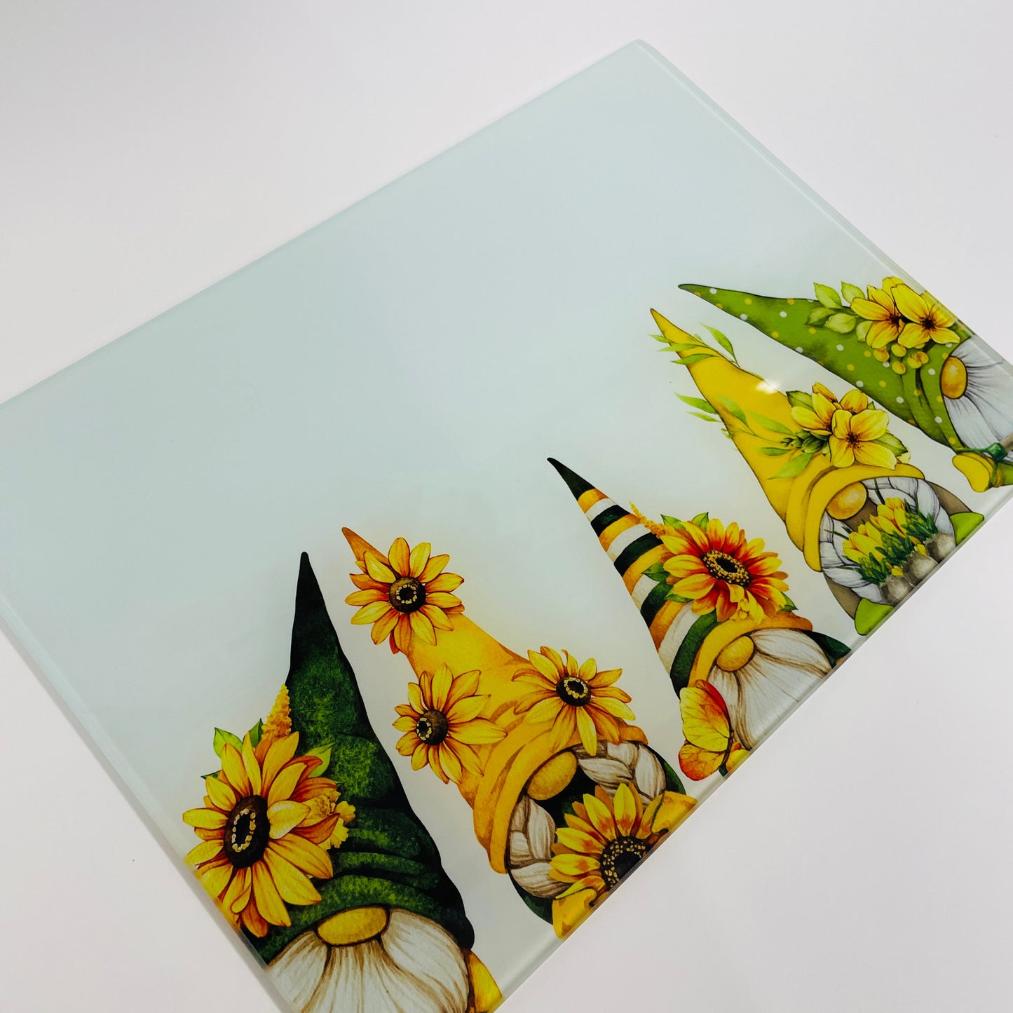 This is a glass chopping board to use in the kitchen. It is available in tow sizes and with two effects - smooth and textured. There are five gonks on the chopping board all peeking their heads out from the bottom.