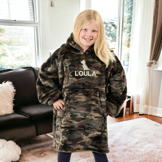 This is a picture of a girl wearing a fleece and sherpa oversized hoodie. The hoodie is embroidered on the front with a little cream dinosaur and a name below it. These are available in children&#39;s and adult sizes and different colours too.