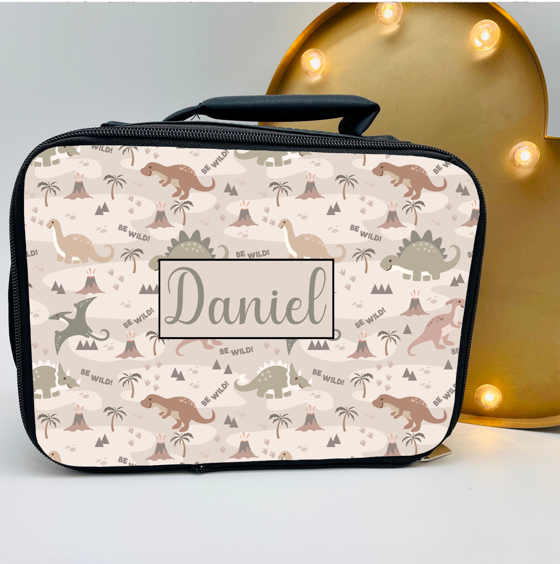 This is a fully insulate black base, full zip close lunch box with carry handle. Printed on the front are many dinosaurs, volcanos and also a name in the middle