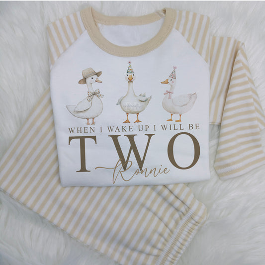 Make your child's birthday extra special with these adorable cotton kids PJs!

Featuring beige sleeves and legs, and a cute print on the chest saying 'When I wake up I will be' with 3 geese.

Personalise it with your child's name for a unique touch. Perfect for sweet dreams and cosy mornings!

The number is changed to your requirements - simply enter your child's age and name in the personalisation box.

These are super soft, long sleeve top and bottom and 100% cotton.
Please take a look at the size guide i