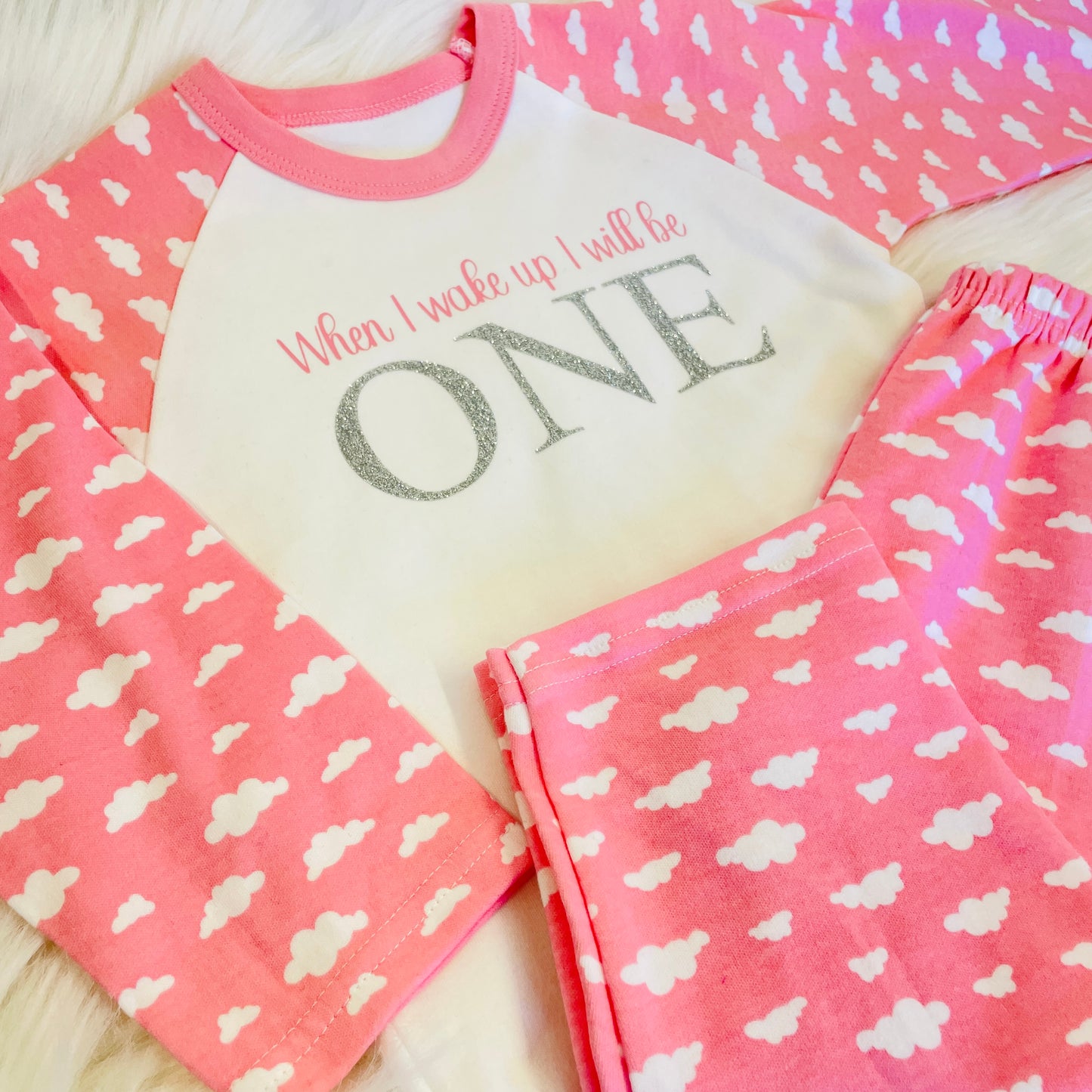 These are 100% cotton pyjamas with pink cloud print arms and trousers. The top is printed with When I wake up in pink and a glittery ONE below it. Lovely pre birthday gift.