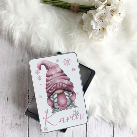 This is a metal tin with detachable lid. The tin is printed on the lid with a festive pink gonk with snowflakes on its hat. The tin is also personalised with a name in pink below the gonk. Use these tins to store small accessories or favourite sweets