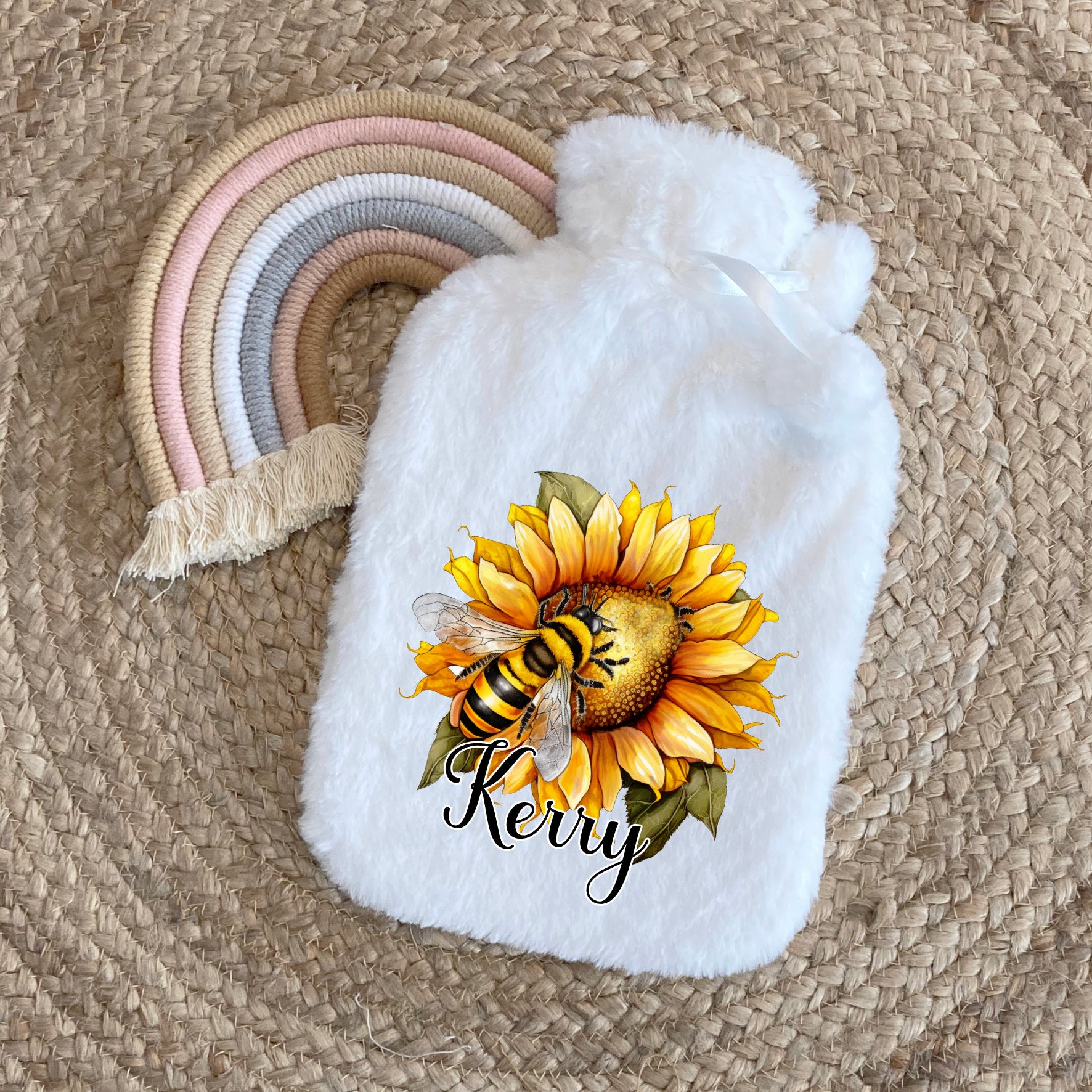 This is a super soft hot water bottle with cover. The cover has a vibrant watercolour sunflower with a bee printed on the front. This gift idea for her is personalised with a name at the bottom of the design. The bottle holds 2 litres of water.