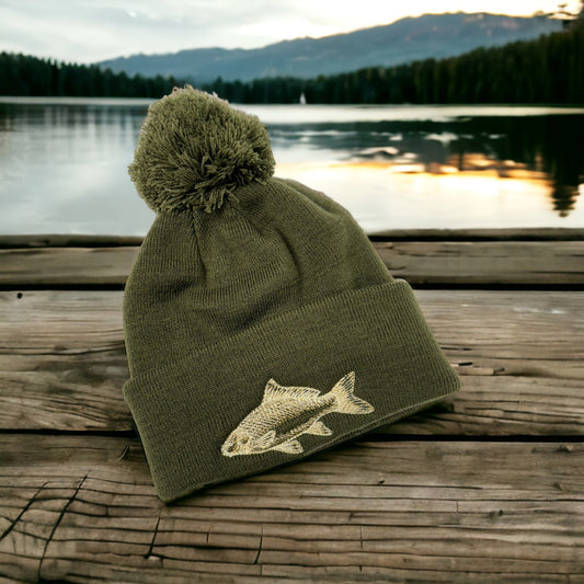 This is a beanie hat with a carp embroidered in cream and gold on the rolled up cuff. These hats are available as a regular beanie or with a pompom hat. Stay warm whilst fishing with your eye catching hat