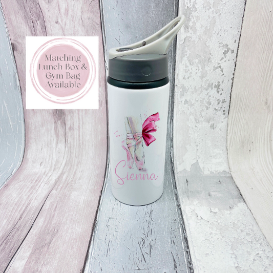 This is a 650ml aluminium flask with a flip up straw and a handle at the top. The flask is printed with an elegant ballet design. The design is watercolour with ballet shoes and a pink bow with a name below.