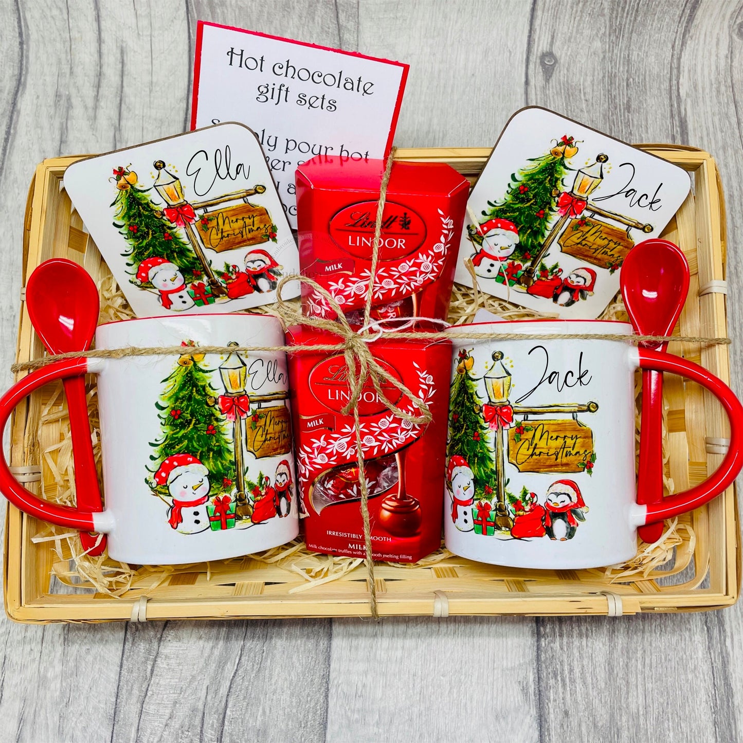 Christmas gift set in a wicker basket filled with a personalised mug, coaster and Lindt chocolates. The design features friends with a Christmas tree, festive street lamp and a ‘merry Christmas’ sign. Ideal Christmas Eve gift. Stocking filler