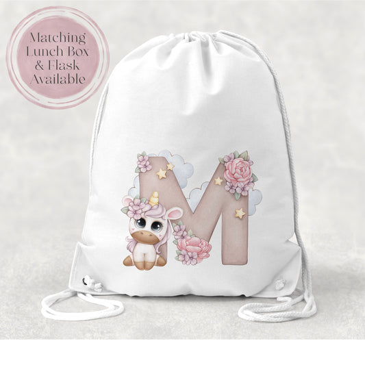 Image of a white PE bag with white drawstrings and a printed image to the front.  The image is of an initial M with flowers and clouds and a cartoon unicorn with big eyes and flowers in its hair.