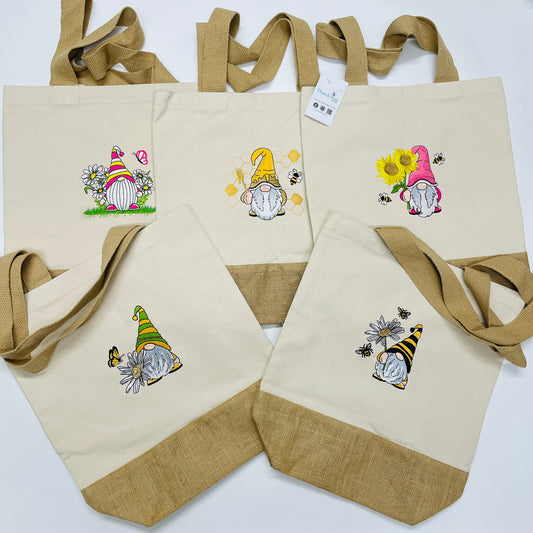 Cotton canvas and jute tote shopping bag. With strong thick jute handles.  Each bag has a Gonk/gnome design embroidered. One is a daisy Gonk, one a sunflower Gonk and the other is a honey bee Gonk. These bags are eco friendly and eye catching