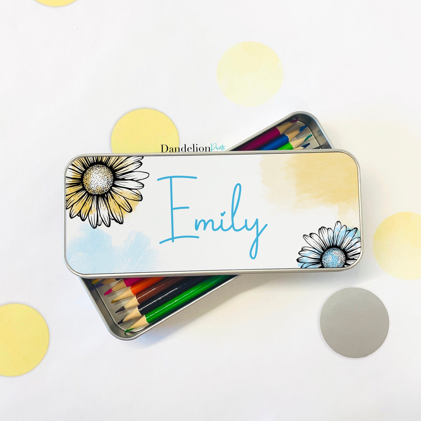 This is a pretty pencil tin with blue and yellow watercolour splashes. In the top left and bottom right corners are a pink and yellow outline daisy with a water colour splash. This pen or pencil tin is printed with a name in the middle.