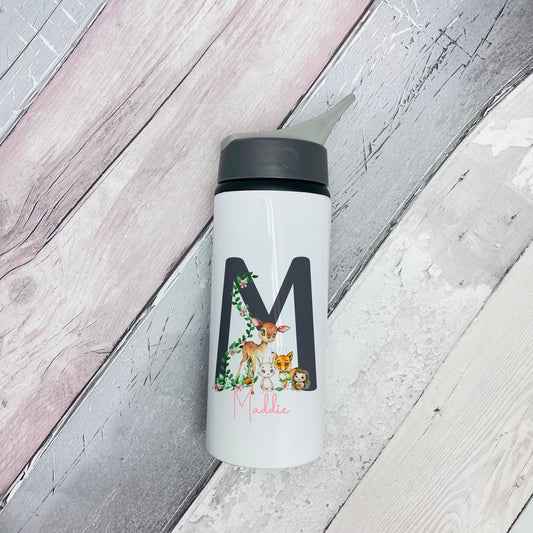 Image of a white metal flask with black top and drinking spout. The main body has a  printed woodland scene with a deer and a rabbit along with the name Maddie