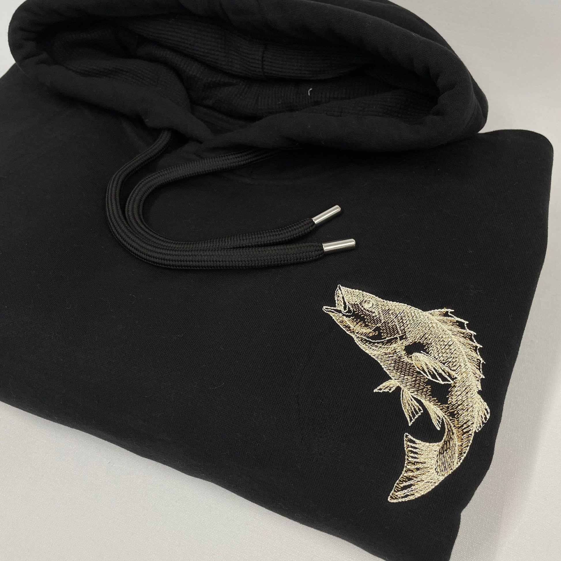 Black organic hoodie with a perch fish embroidered in gold on the left breast. Other designs available include, carp, catfish, pike and salmon.  Ideal for any fishing/ angling lover, these are super soft and luxurious. Embroidery is very detailed