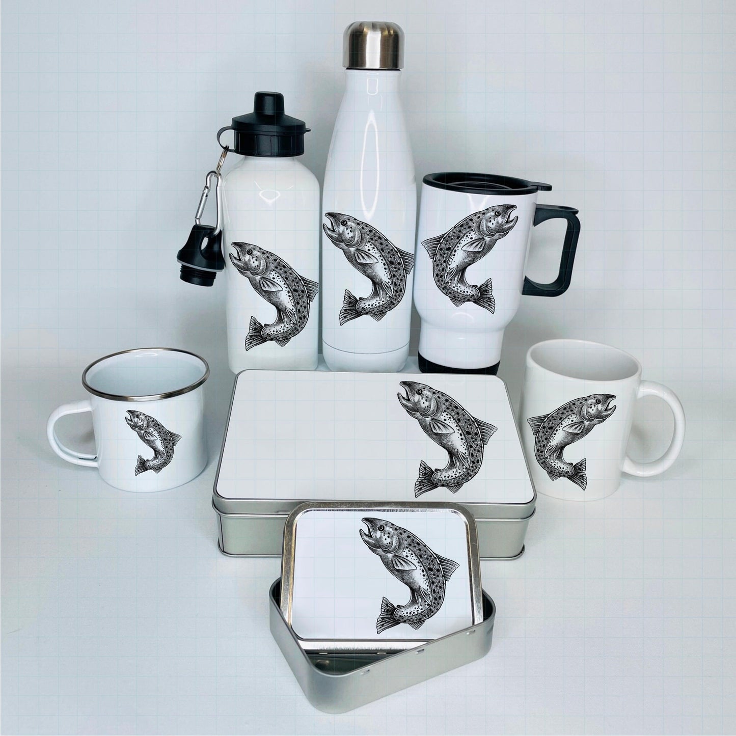 There are various fishing accessories available here. The fish printed on the items is a salmon in a black and white sketch. Items are flasks, tins and mugs