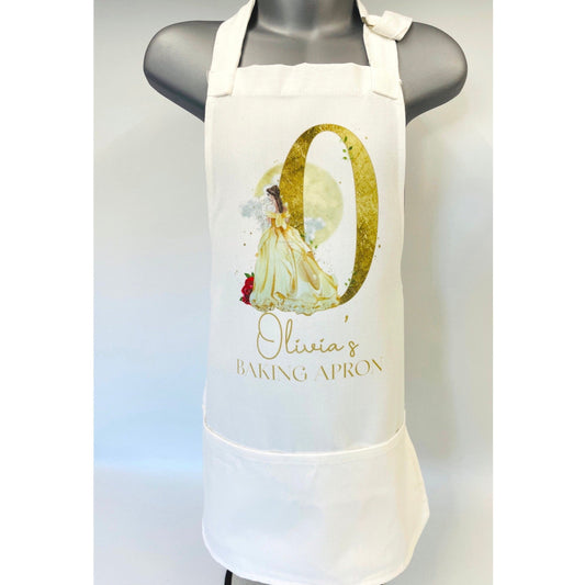 This is a childrens apron suitable for ages 3-7. Printef on the front is a big gold initial with a beautiful princess wearing a gold dress. Complemented with red roses. Below the design the text says Olivias baking apron.